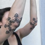 Dual flower tattoos on both forearms