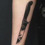 Face reflection on a blade tattoo