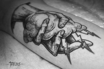 Hand holding a cloud tattoo