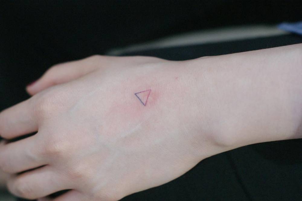 Hand-poked spectrum triangle tattoo