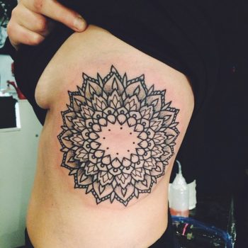 Large mandala tattoo on the left rib