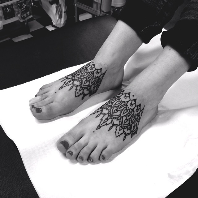 Matching ornament tattoos on both feet