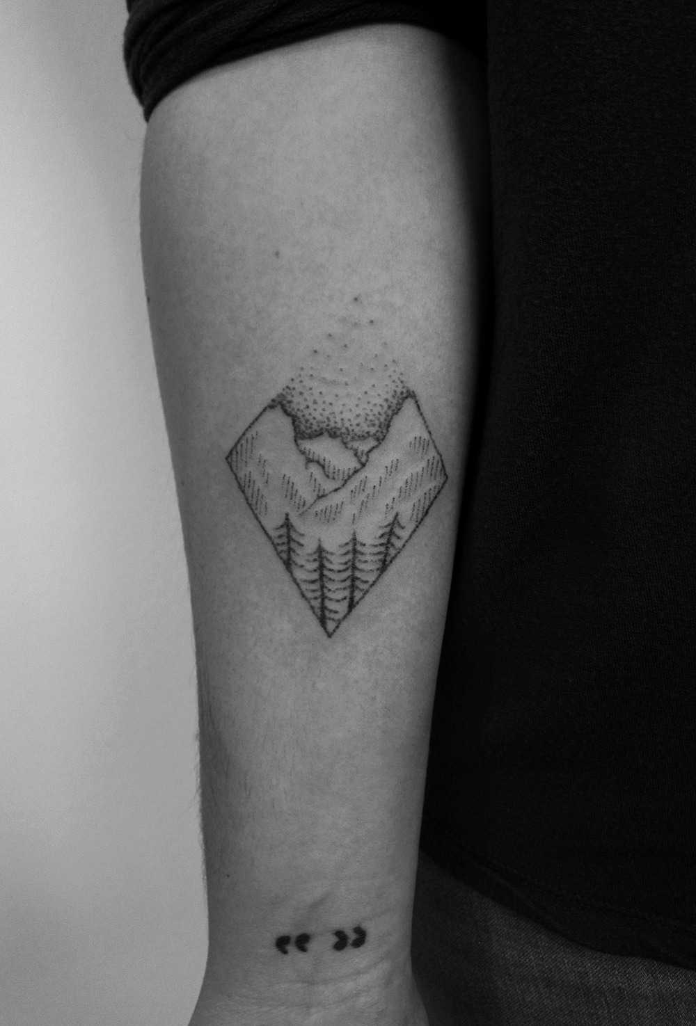 Minimalist mountain scene tattoo by Regius Ink