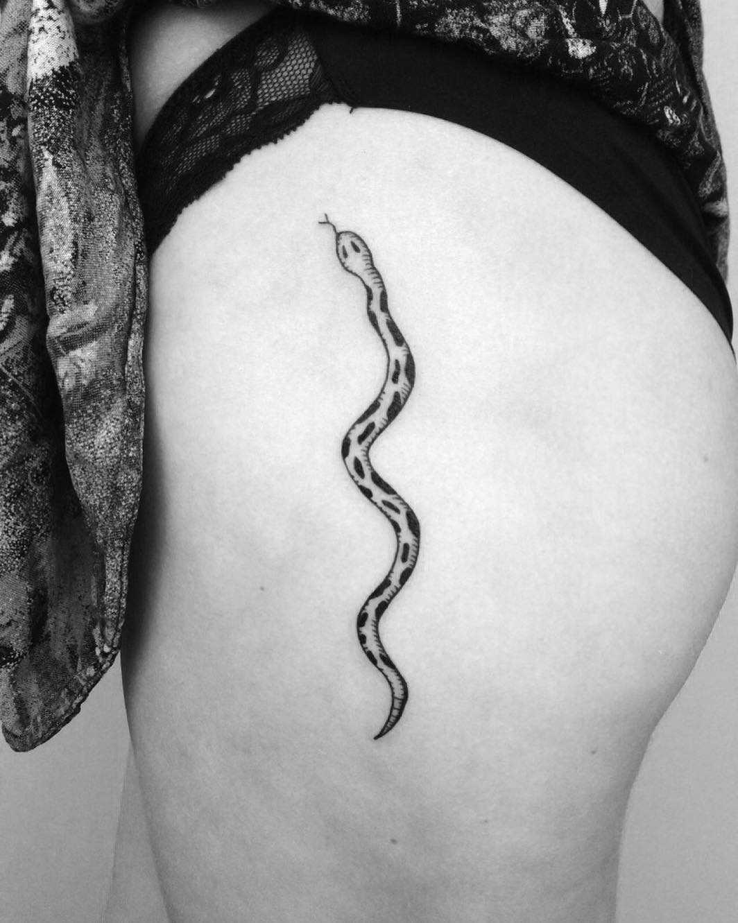 Minimalist snake tattoo on the left hip