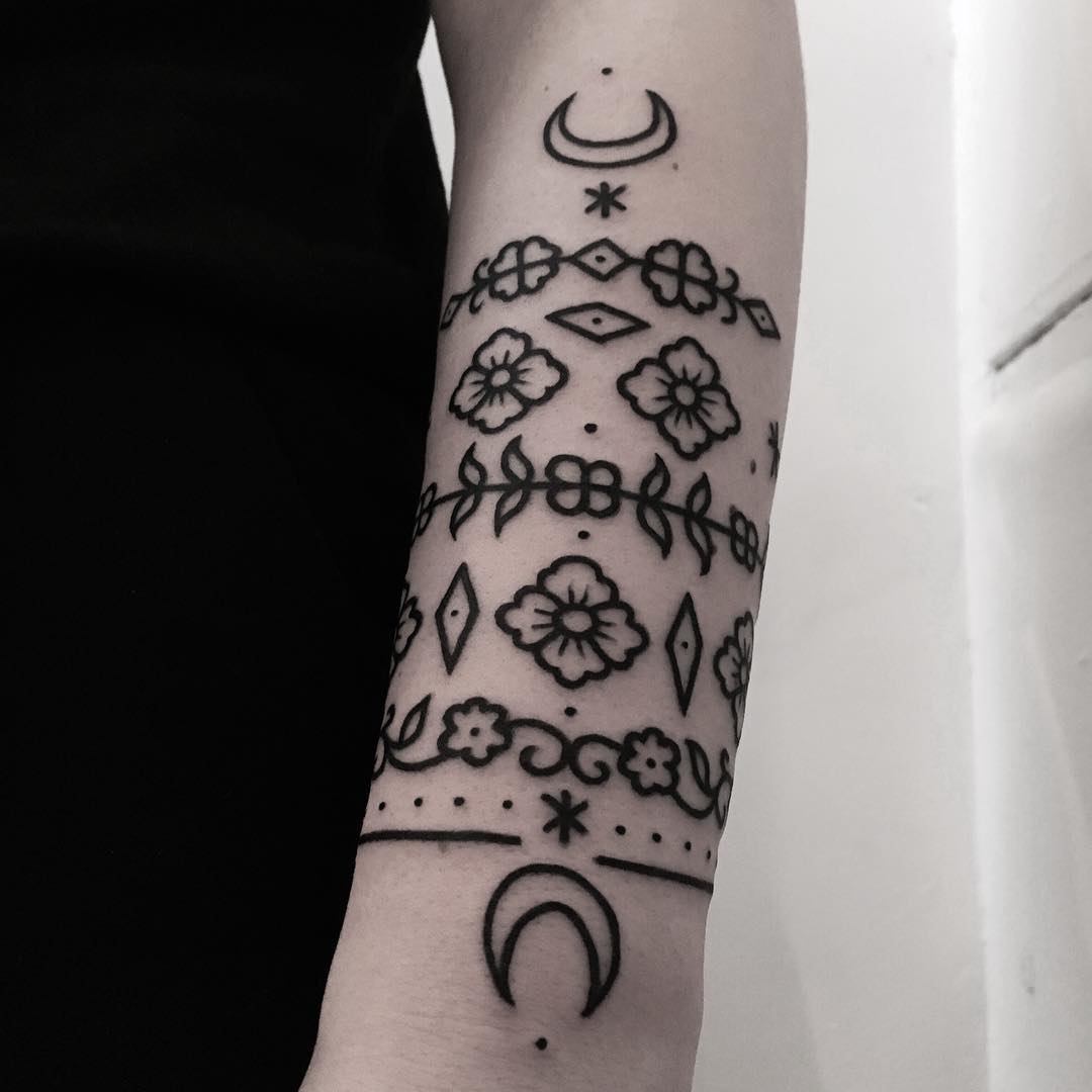 Ornamental flowers and moons tattoo