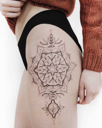 Ornamental mandala tattoo on the left hip