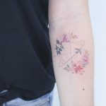 Plane, compass, and flowers tattoo