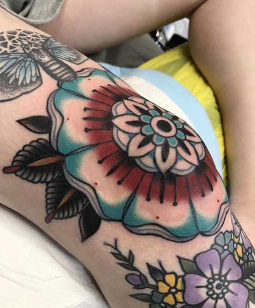 Red and blue mandala tattoo on the knee