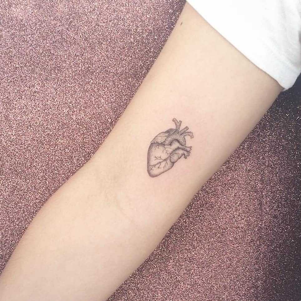 Small anatomical heart tattoo on the arm