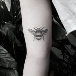 Small black and grey bee tattoo