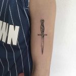 Small dagger tattoo on the arm