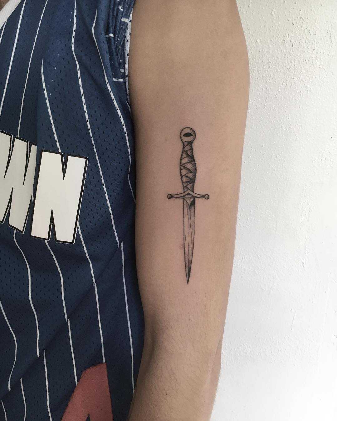 Small dagger tattoo on the arm