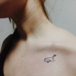 Small whale tattoo on the clavicle