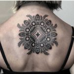 Stylized floral mandala tattoo on the back