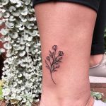 Tiny flower tattooed on the calf