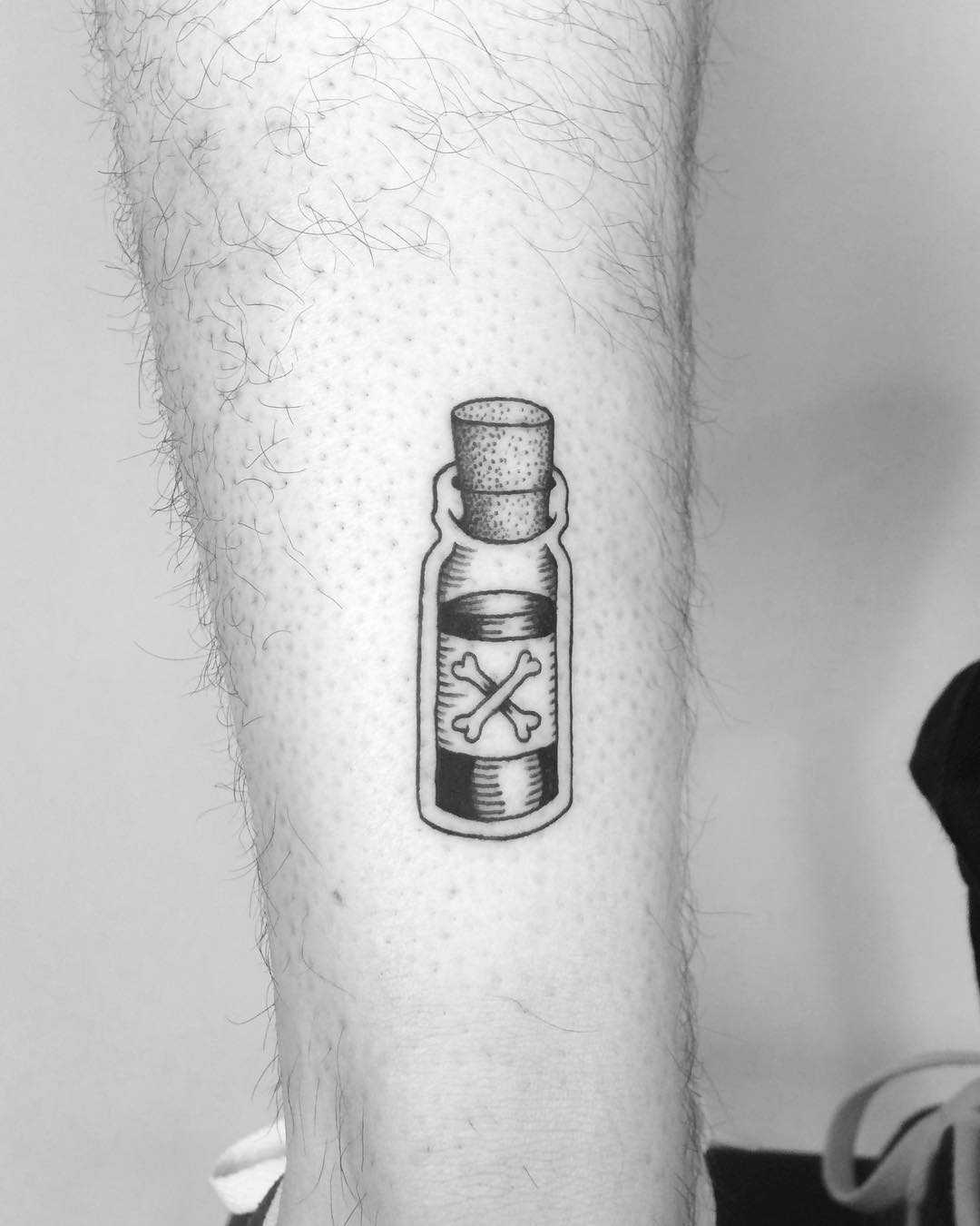 Tiny poison bottle tattoo on the calf