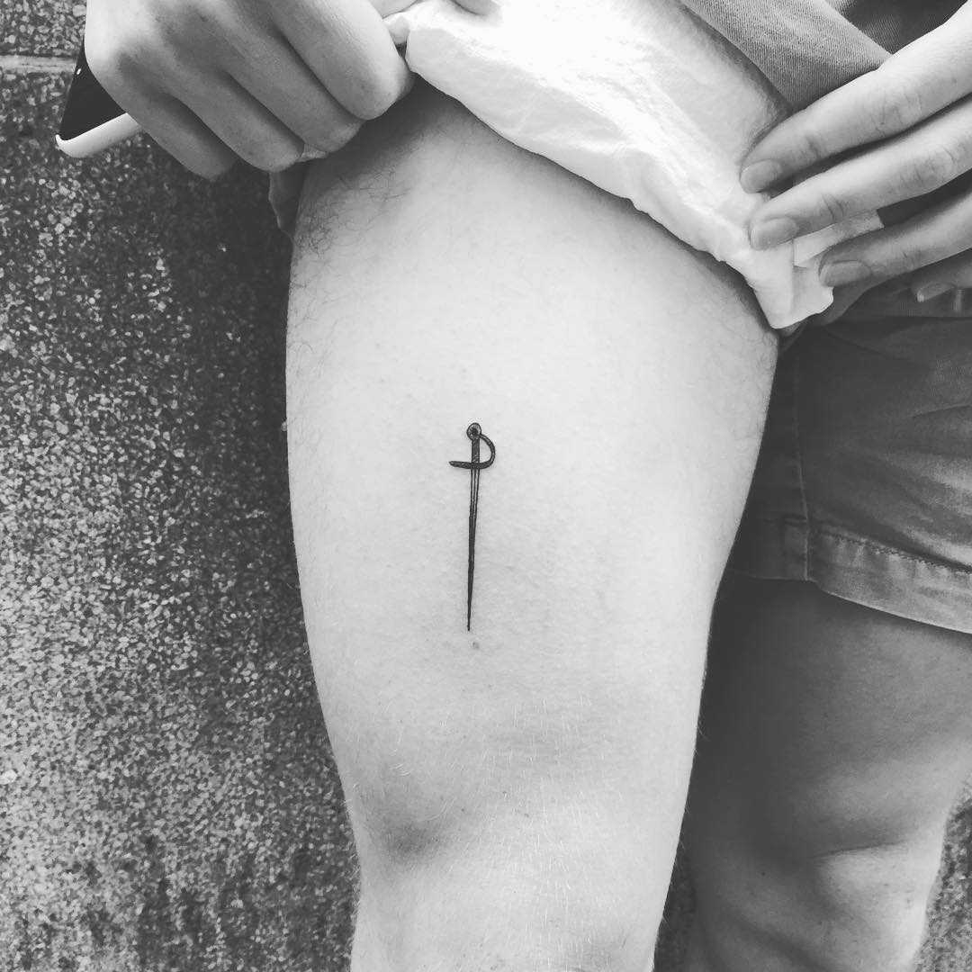 Tiny sword tattoo on the thigh