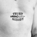 Trust nobody tattoo on the sternum