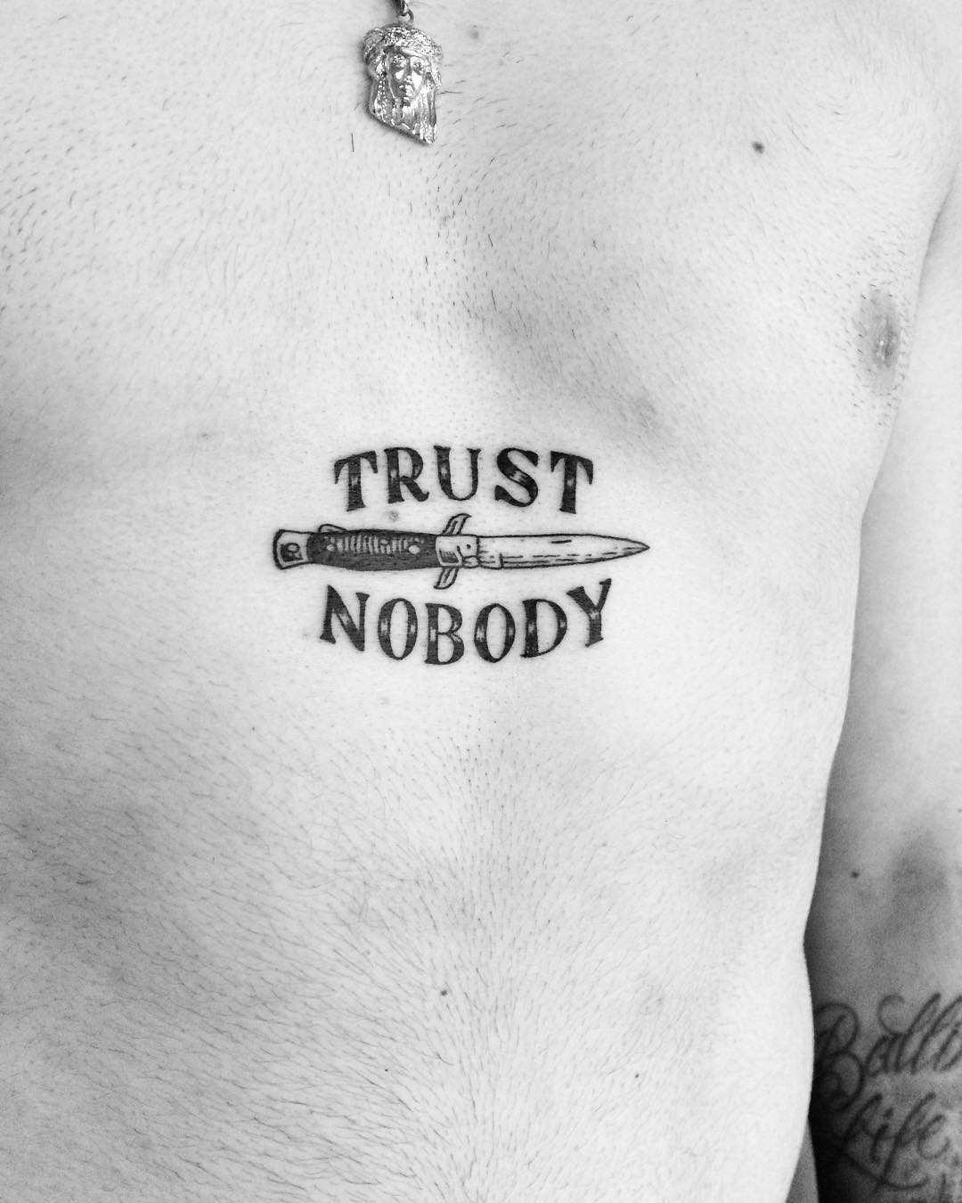 Trust nobody tattoo on the sternum