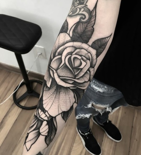 Black and white rose tattoo on the forearm