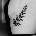 Black leaves tattoo on the rib cage