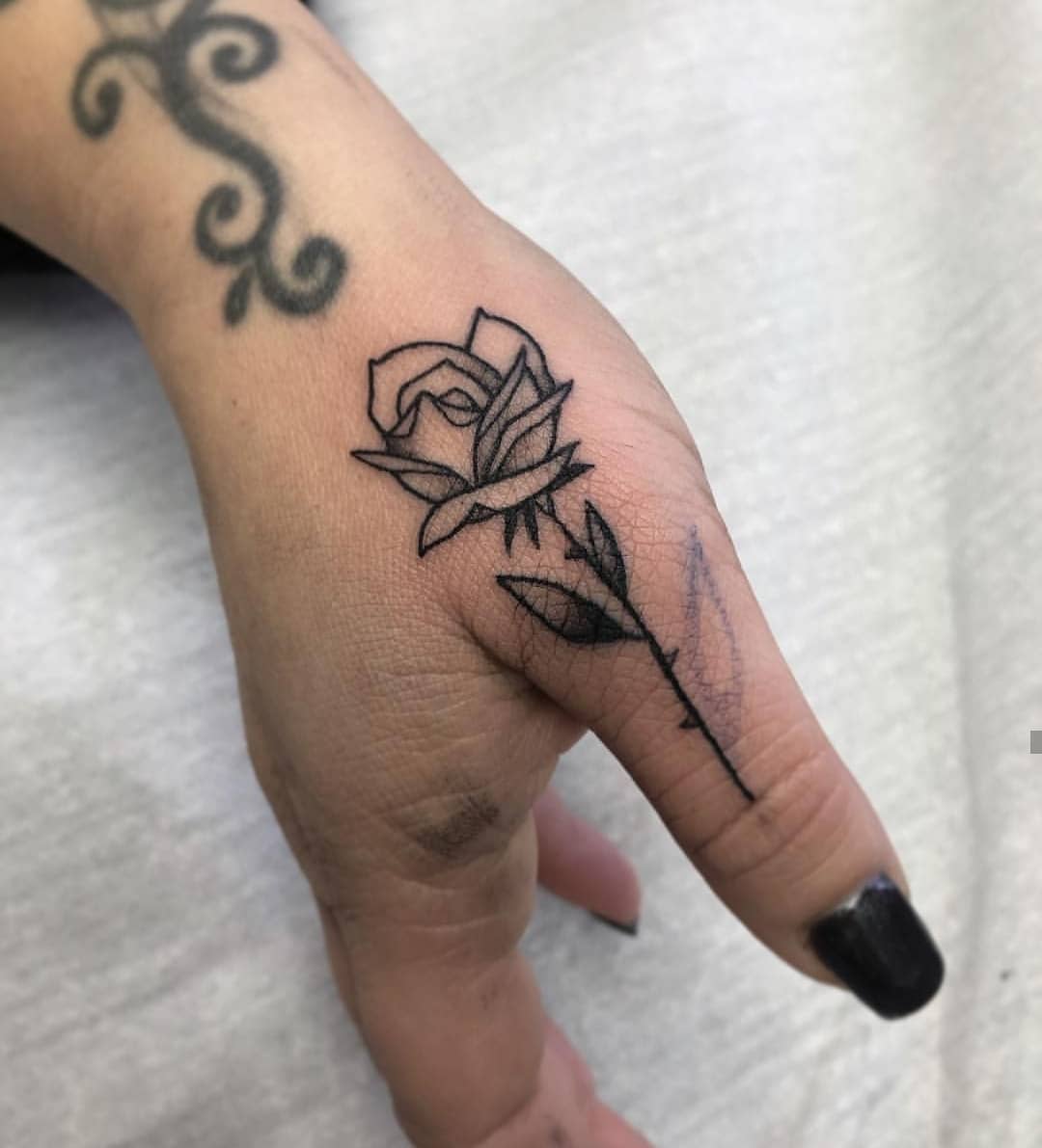 Black rose on the right thumb - Tattoogrid.net