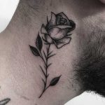 Black rose tattoo on the neck
