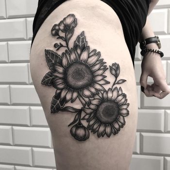 Black sunflower tattoo on the thigh