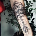 Black tree tattoo on the forearm