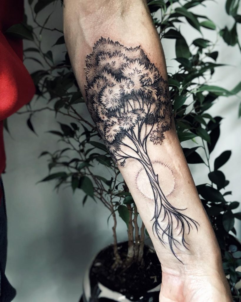 Black tree tattoo on the left forearm