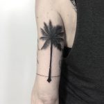 Blackwork palm tree tattoo on the arm