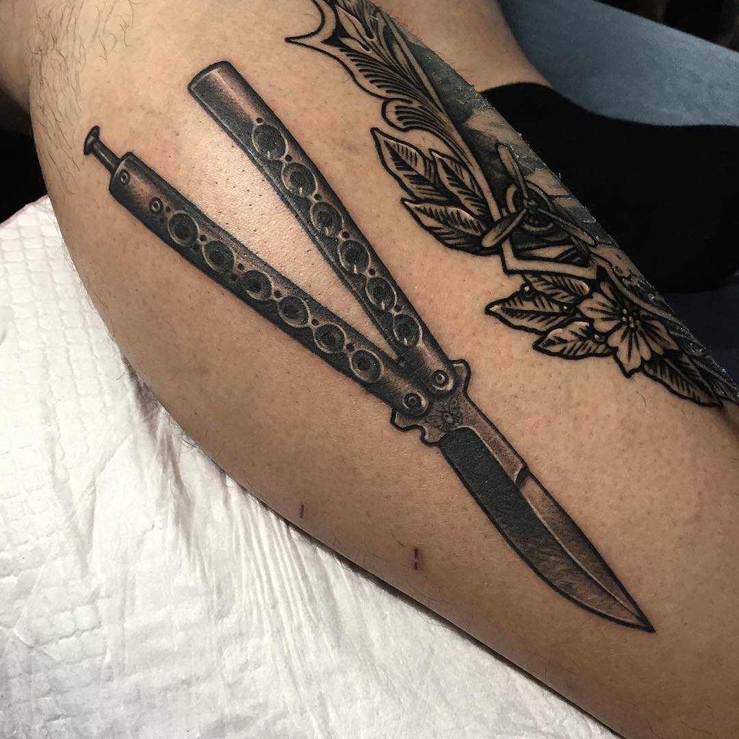Butterfly knife tattoo on the calf