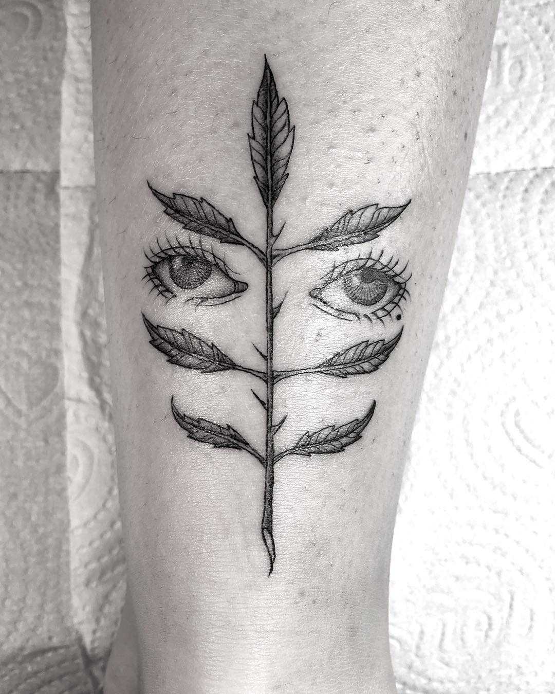 Chicano eyes and branch tattoo