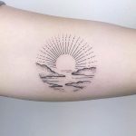 Circular sunset and clouds tattoo