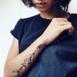 Cosmic arrow tattoo on the forearm