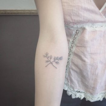 Crossed dry flowers tattoo