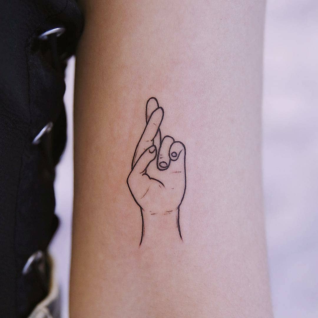 Crossed fingers tattoo