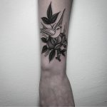 Flower and bird tattoo on the forearm