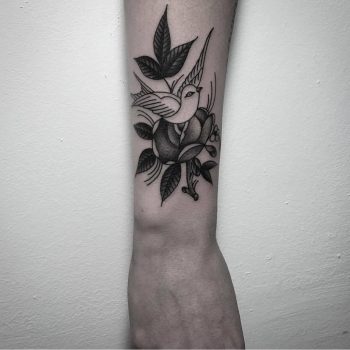 Flower and bird tattoo on the forearm