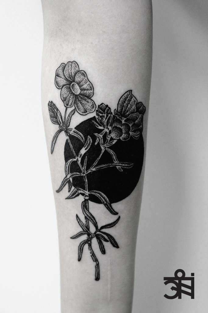 Flower and black sun tattoo