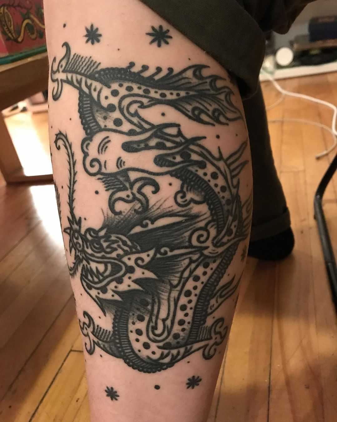 Funny dragon tattoo on the calf