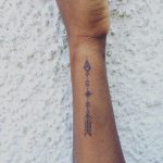 Hand-poked arrow tattoo on the wrist