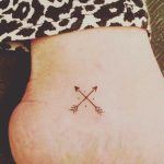 Hand-poked crossed arrows tattoo
