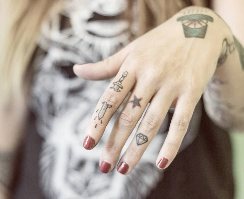 Hand-poked sword tattoo on the finger