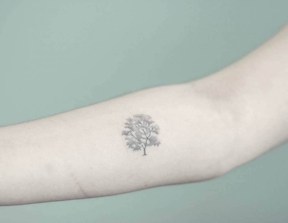 Hand-poked tree tattoo on the forearm
