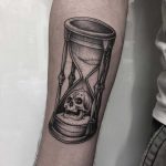 Hourglass and skull done at Primordial Pain Tattoo