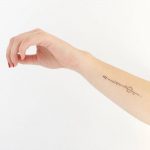 Minimalist arrow tattoo on the forearm