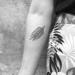 Minimalist fern leaf tattoo on the forearm