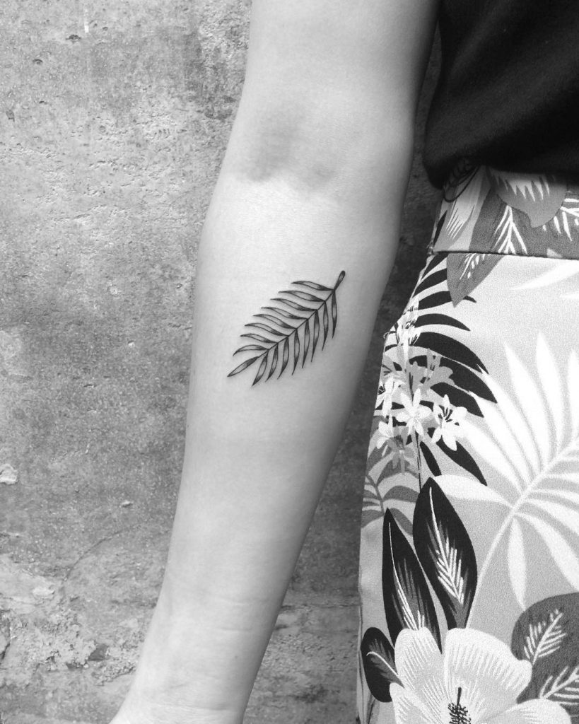 Minimalist fern leaf tattoo on the forearm