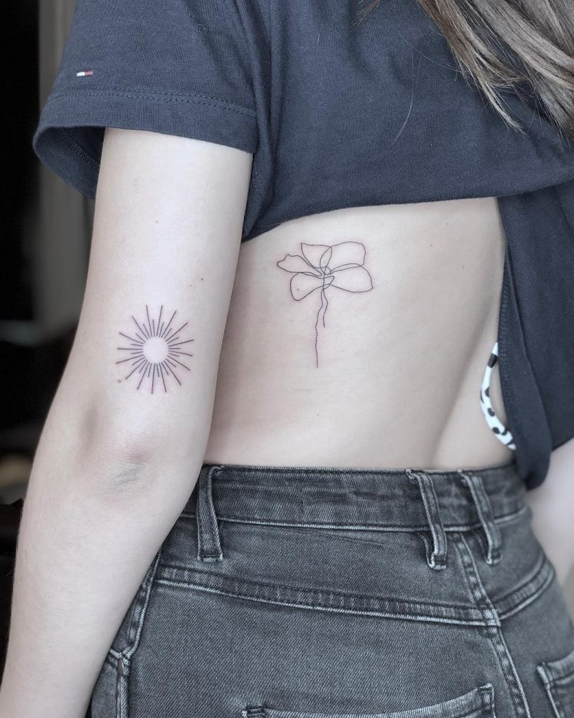 Minimalist sun and flower tattoo